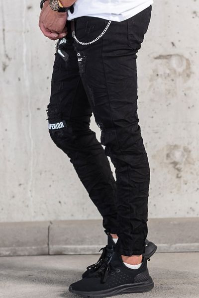 vaqueros streetwear negros con estampado de texto, superficie rota y cadena