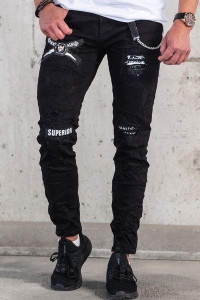 vaqueros streetwear negros con estampado de texto, superficie rota y cadena
